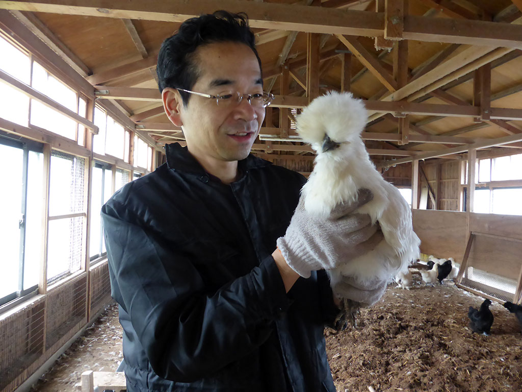 松本ファーム代表松本光弘と烏骨鶏の写真